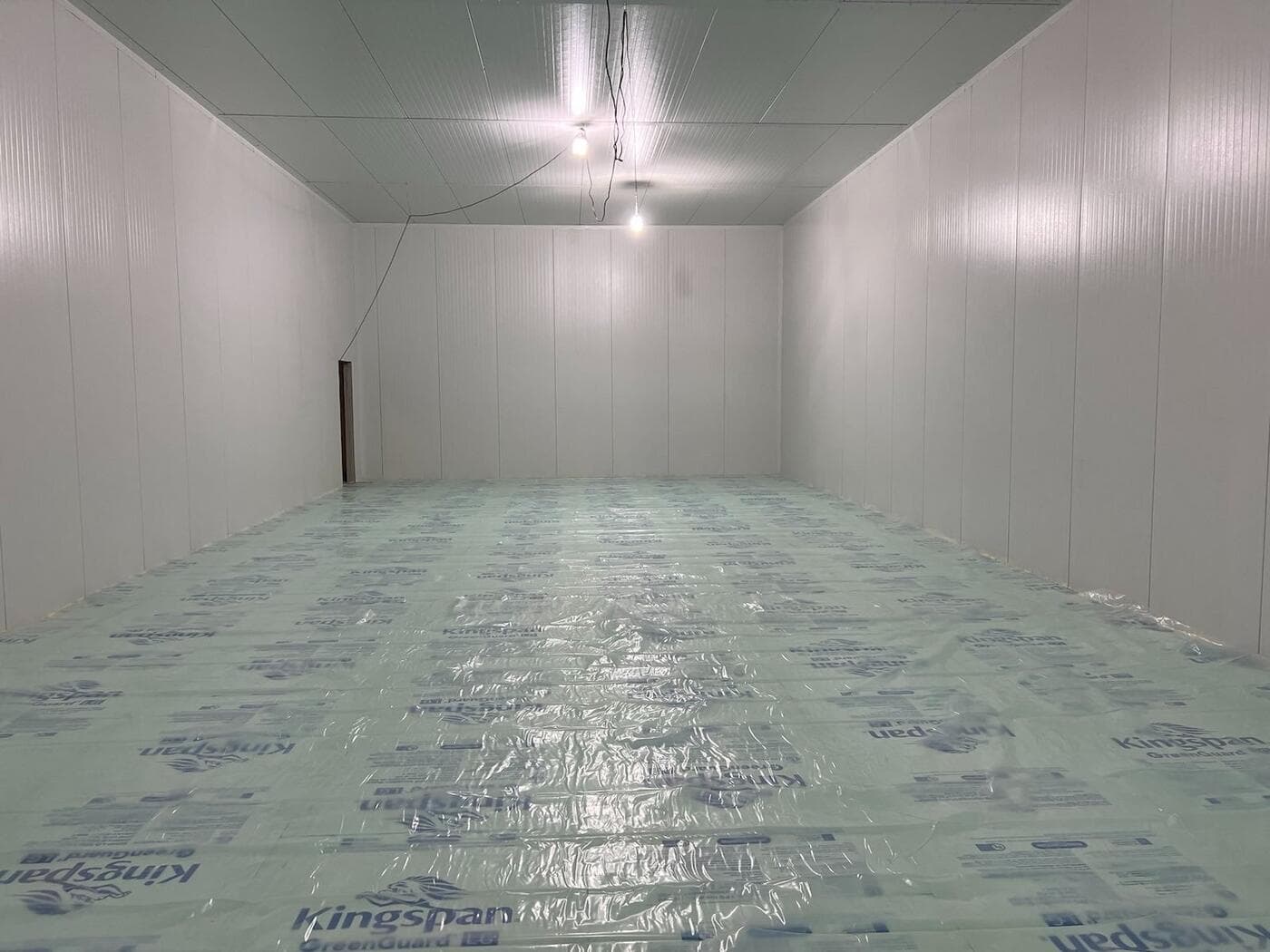 Finished climate-controlled room with insulated wall and ceiling panels